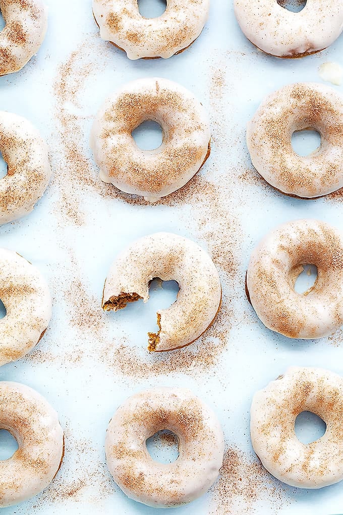 top view of baked pumpkin donuts with a bite missing out of one of them.