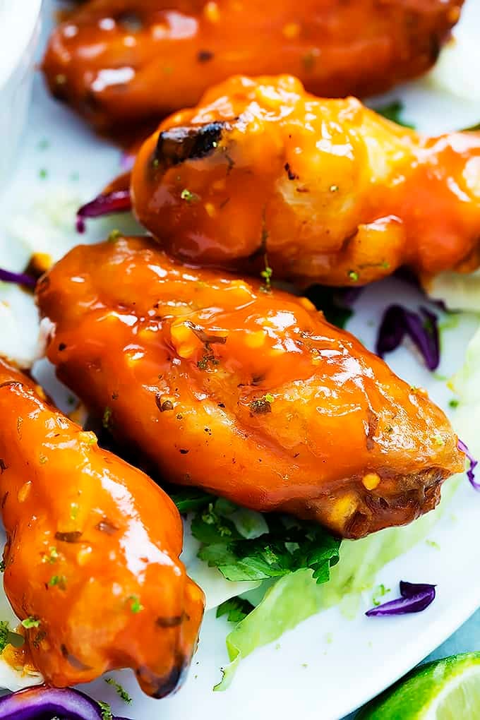 close up of spicy honey lime chicken wings on a plate.