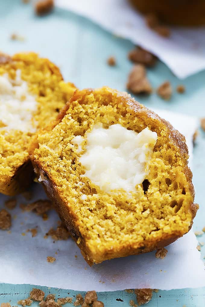 close up of a pumpkin cream cheese streusel muffin cut in half and laid on it's side.