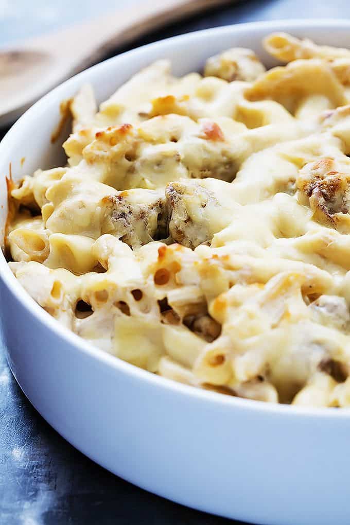close up of baked cheesy sausage penne in a bowl.