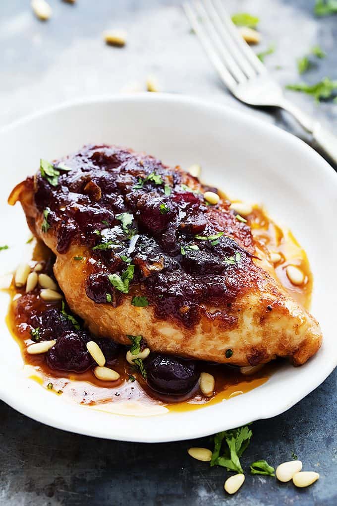 slow cooker cranberry chicken on a plate with a fork on the side.