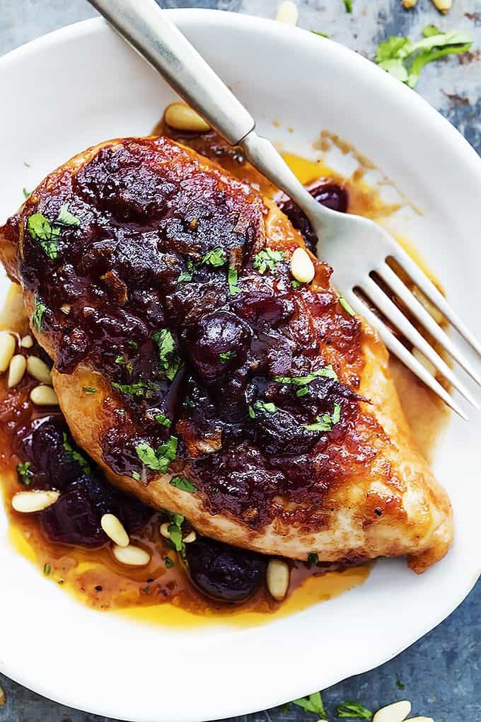 top view of slow cooker cranberry chicken with a fork on a plate.