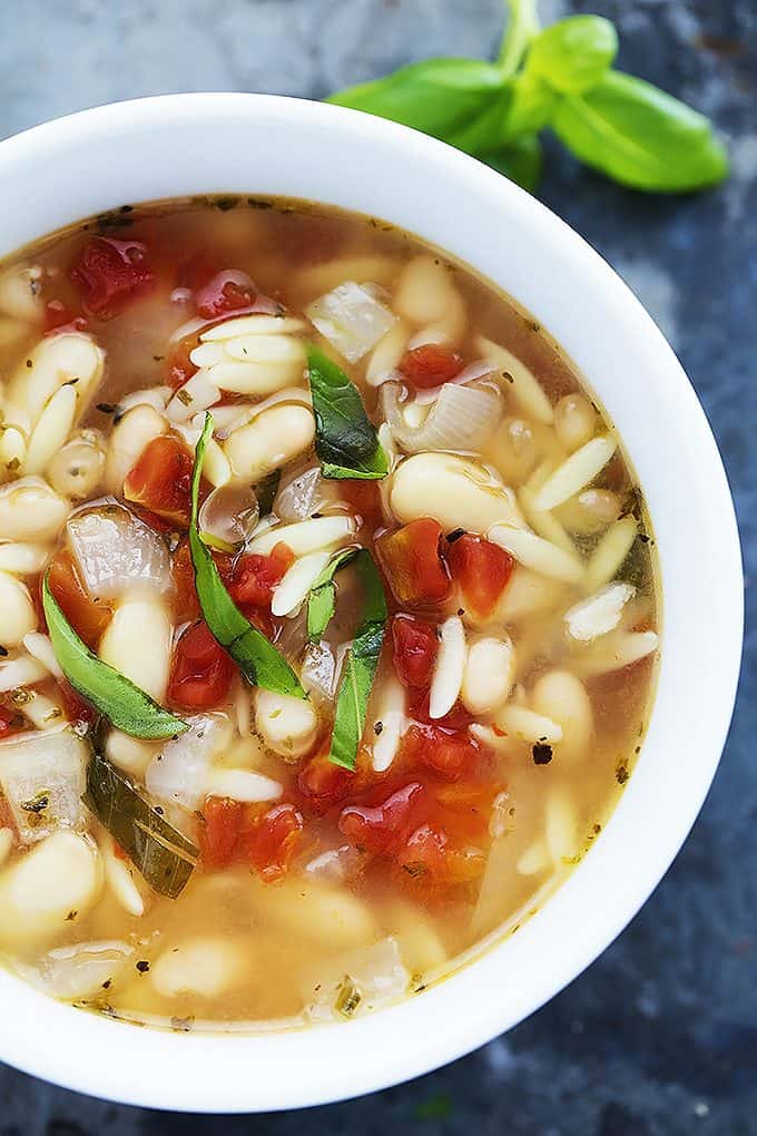 close up top view of Italian white bean & orzo soup in a bowl.