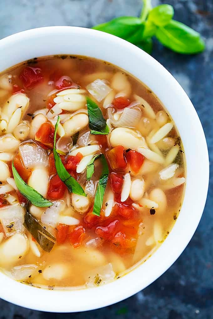 close up top view of Italian white bean & orzo soup in a bowl.