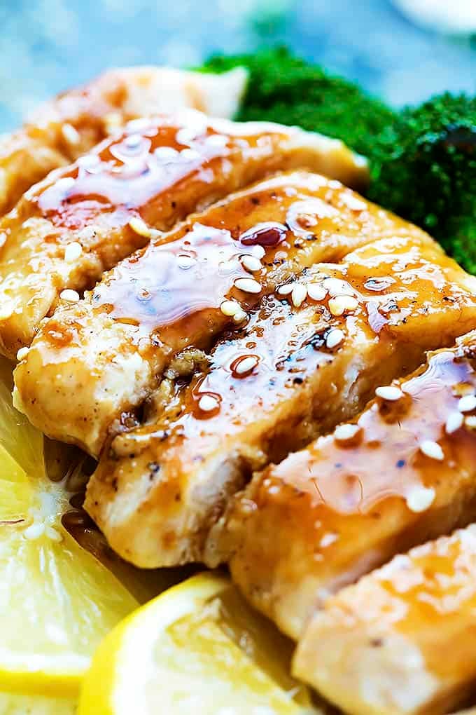 close up of lemon teriyaki chicken with lemon slices and broccoli on the sides.