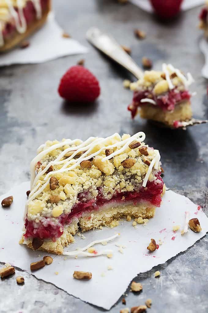 a raspberry crumb pie bar with a bite missing with the bite on a fork in the background.