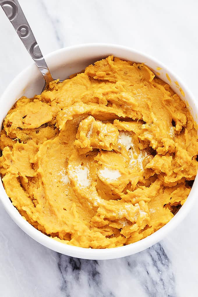 top view of a bowl of slow cooker mashed sweet potatoes with a spoon.