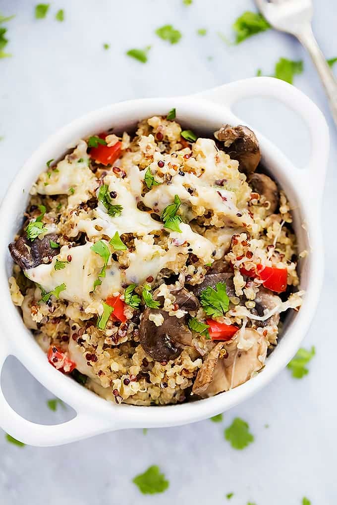 top view of slow cooker cheesy mushroom quinoa in a bowl with a fork on the side.