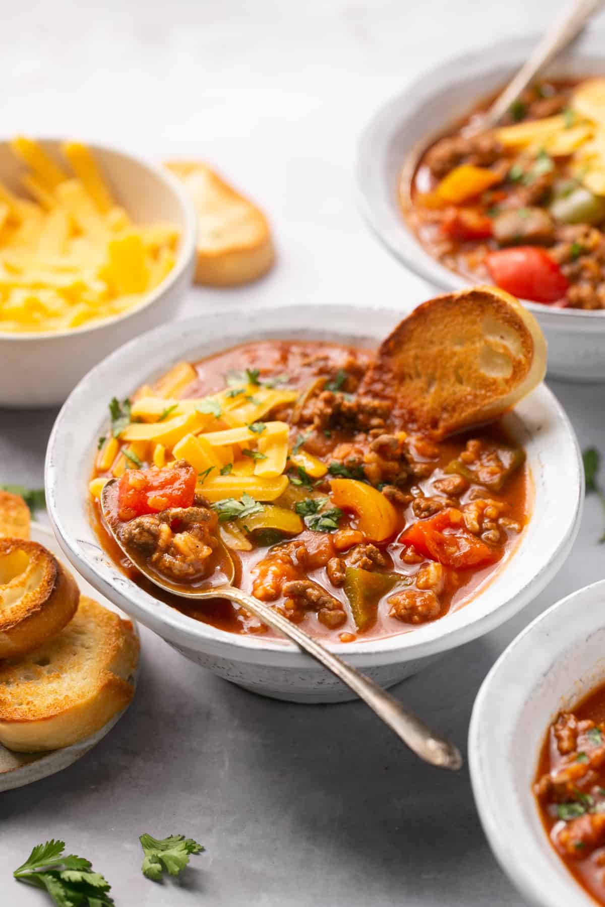 stuffed pepper soup in a bowl with toppings on table