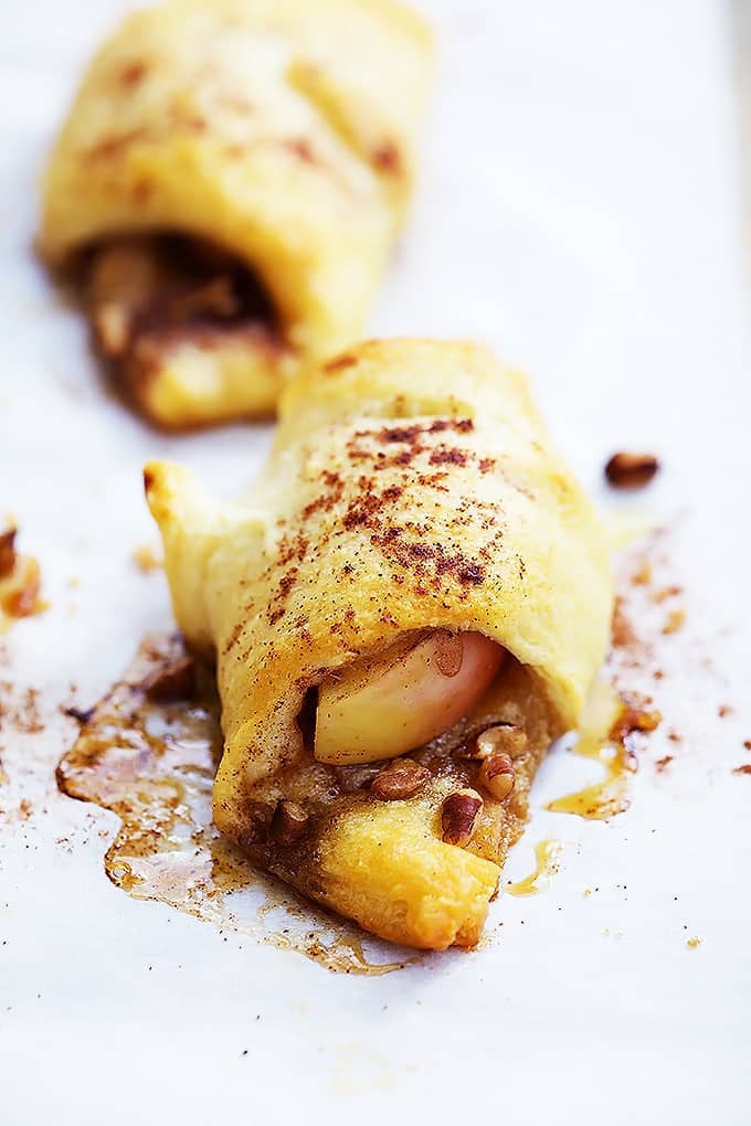 a apple pie roll up without icing on top with another roll up behind it.