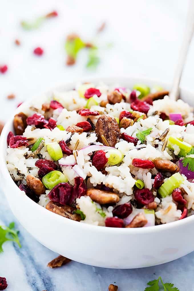 cranberry pecan wild rice salad with a spoon in a bowl.