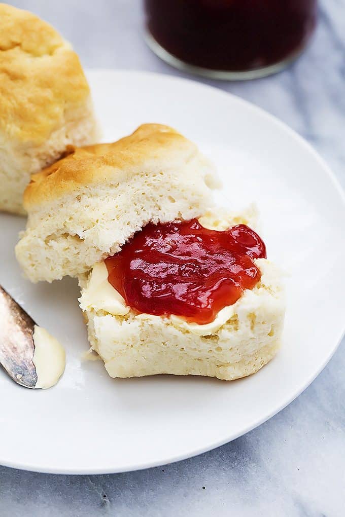 a Knott's Berry Farm buttermilk biscuit with butter and jam on a plate.
