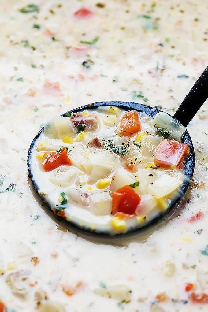 close up of a serving spoon in slow cooker potato bacon corn chowder.