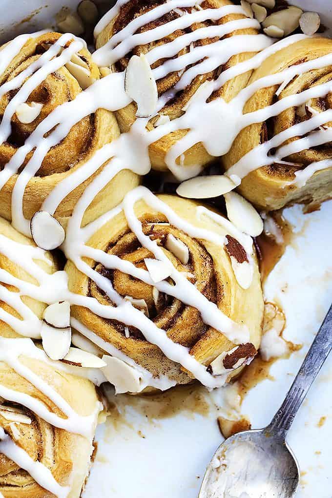 close up top view of flaky almond cinnamon buns with a spoon on the side.