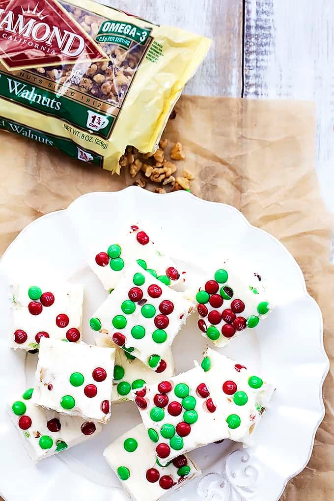 top view of Christmas fudge on a plate with a bag of walnuts on the side.