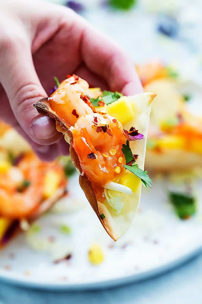 a hand holding up a firecracker shrimp wonton taco.