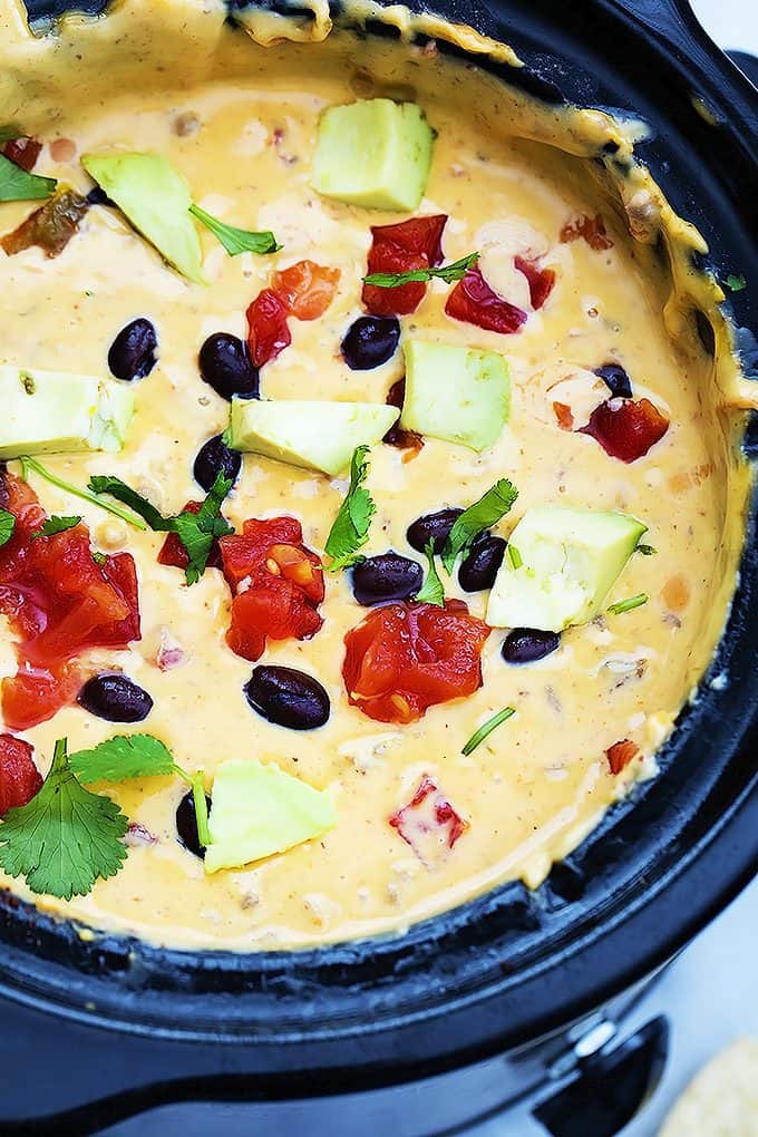 close up top view of slow cooker taco queso dip in a slow cooker.