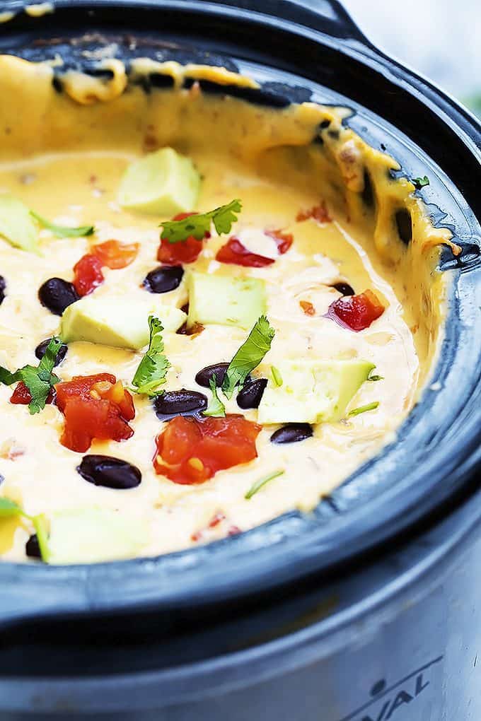 close up of slow cooker taco queso dip in a slow cooker.