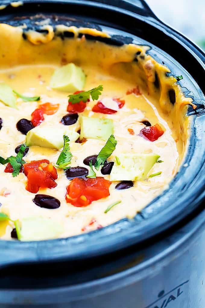 close up of slow cooker taco queso dip in a slow cooker.