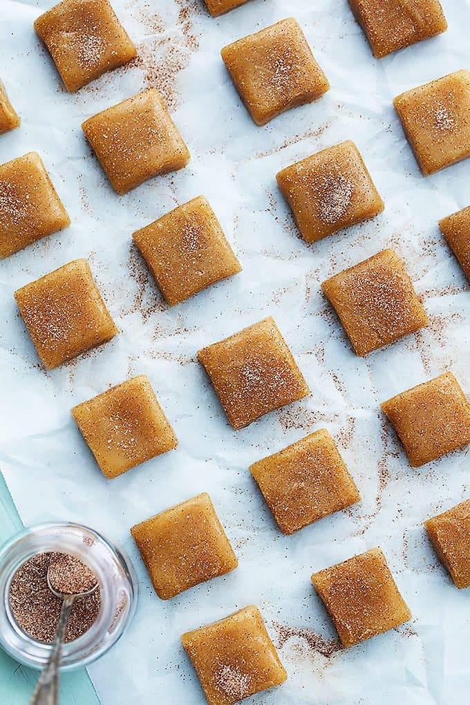 top view of vanilla cinnamon caramels with a mason jar of cinnamon sugar and a spoon on the side.