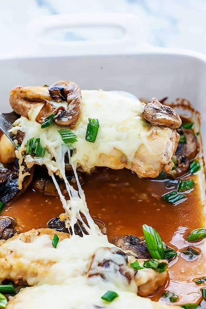 a spatula lifting up a piece of chicken lombardy from a baking tray.