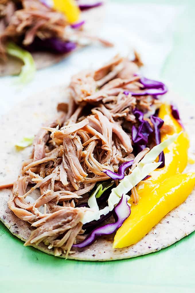 an open kalua pork taco with another taco in the background.