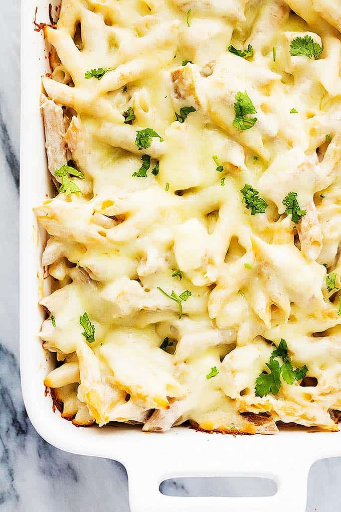 close up of chicken alfredo baked penne in a baking pan.