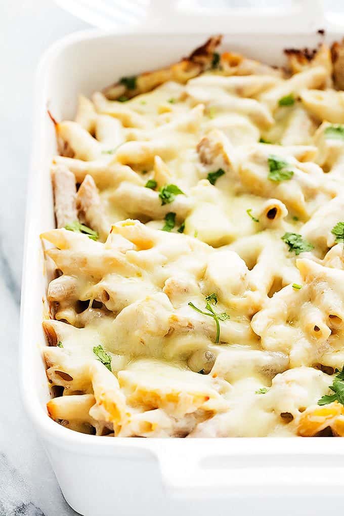 close up of chicken alfredo baked penne in a baking pan.