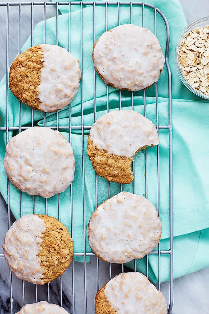 top view of iced oatmeal cookies on a cooling rack with some half iced.