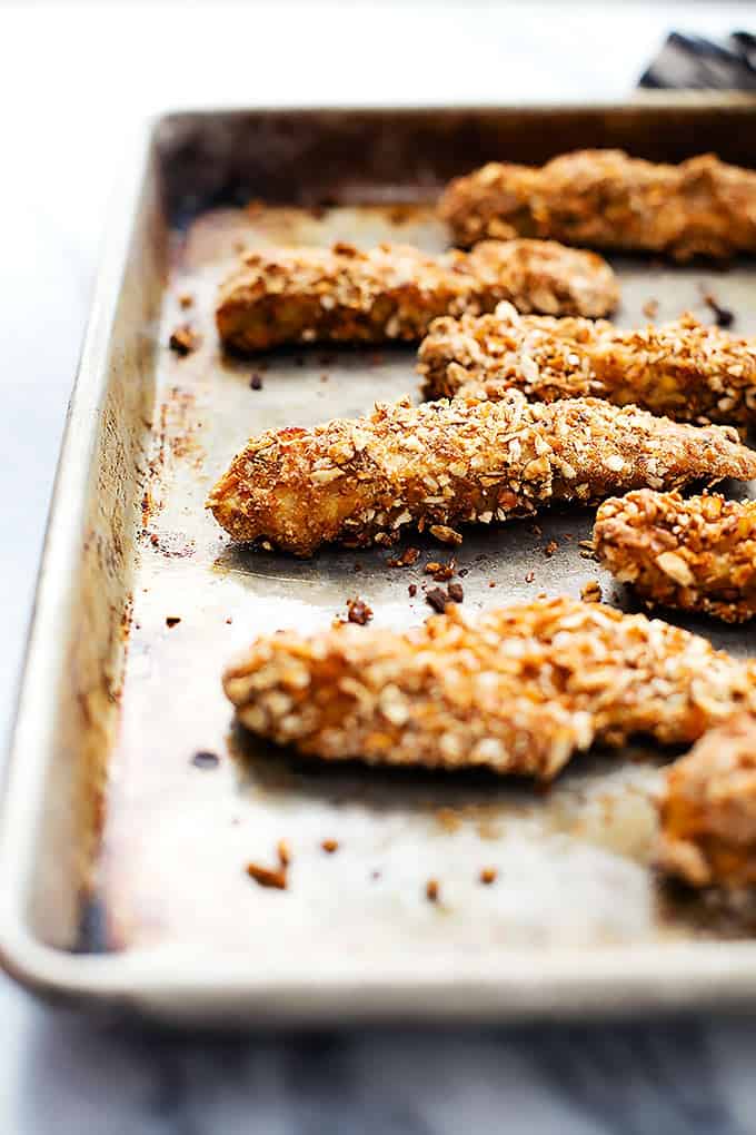 baked pretzel crusted chicken tenders on a baking sheet.