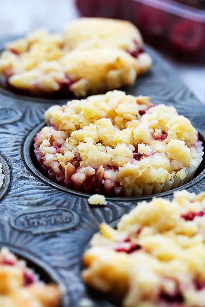 close up of raspberry crumb muffins in a muffin tin.