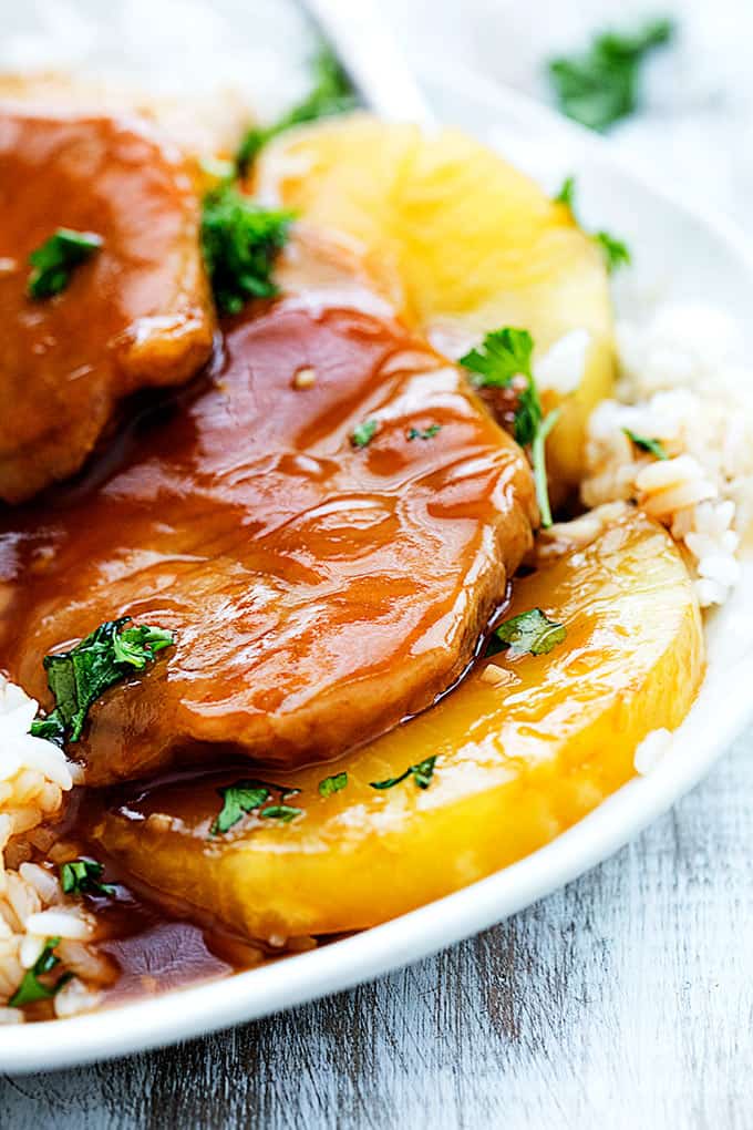 close up of slow cooker Hawaiian pork chops on rice on a plate.