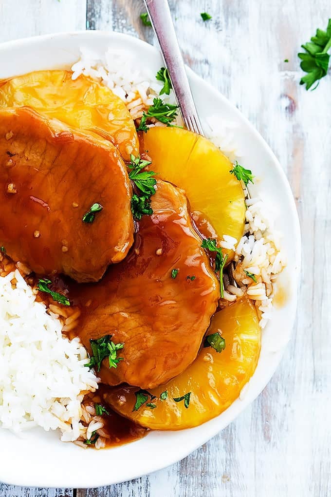 top view of slow cooker Hawaiian pork chops on rice with a fork on a plate.