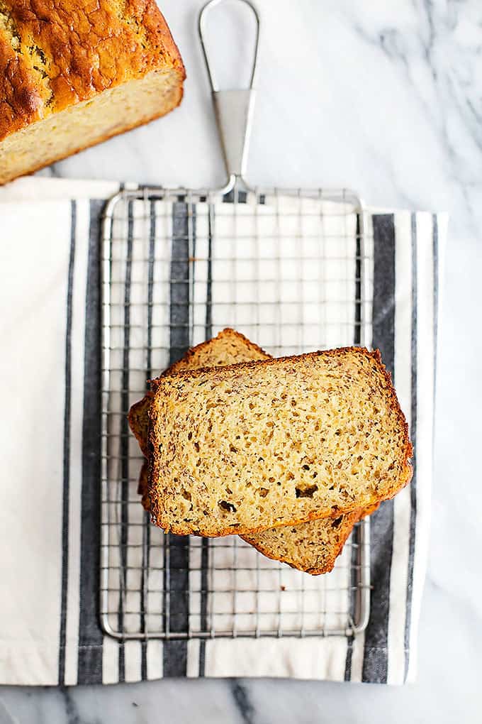 top view of stacked slices of brown butter banana bread on a cooling rack with the rest of the loaf on the sdie.