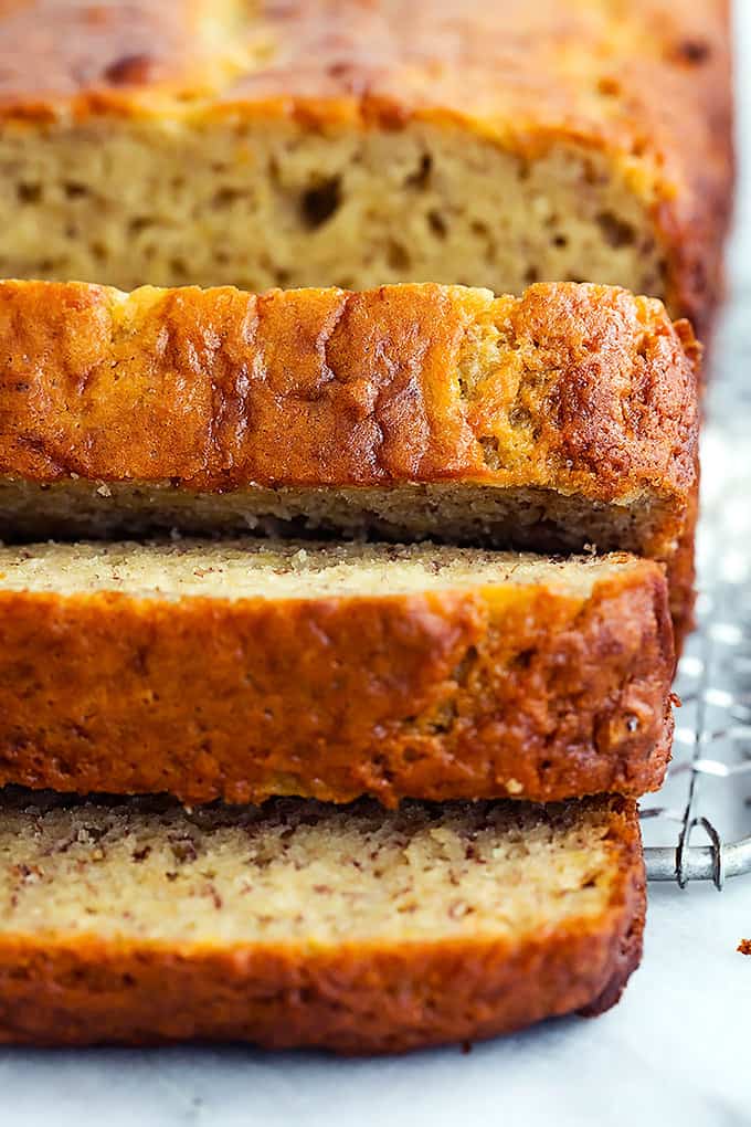close up of a loaf of brown butter banana bread with the front cut in slices.
