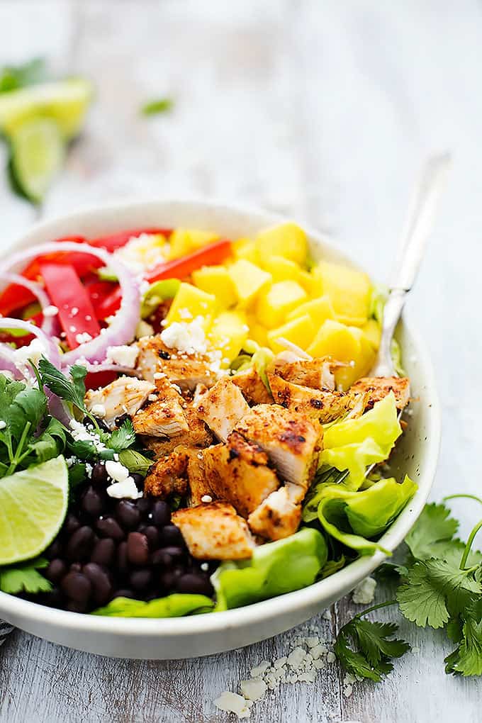 mango chipotle chicken salad with a fork in a bowl.
