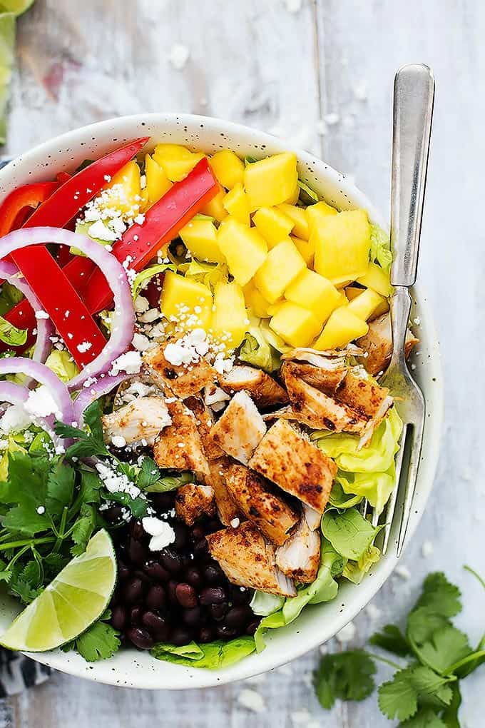 top view of mango chipotle chicken salad with a fork in a bowl.