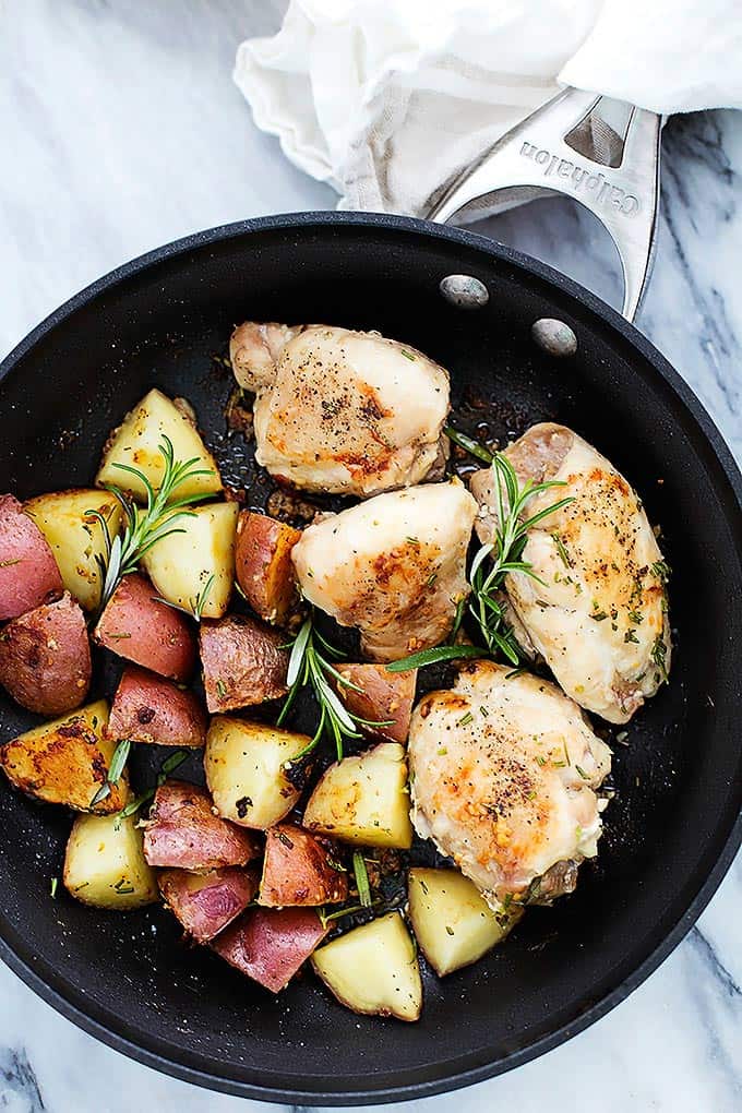 top view of rosemary chicken and potatoes in a skillet.