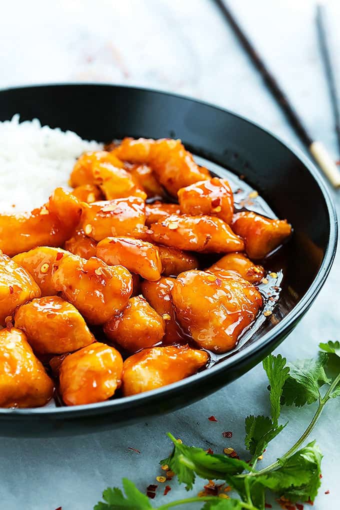 slow cooker firecracker chicken with rice in a bowl with chopsticks on the side.