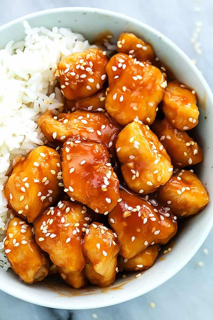 close up top view of slow cooker honey sesame chicken and rice in a bowl.