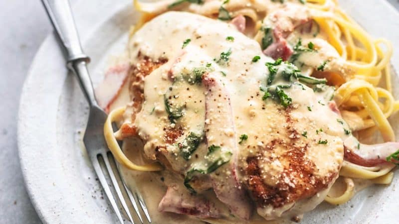 chicken with sauce with spinach over fettuccine noodles