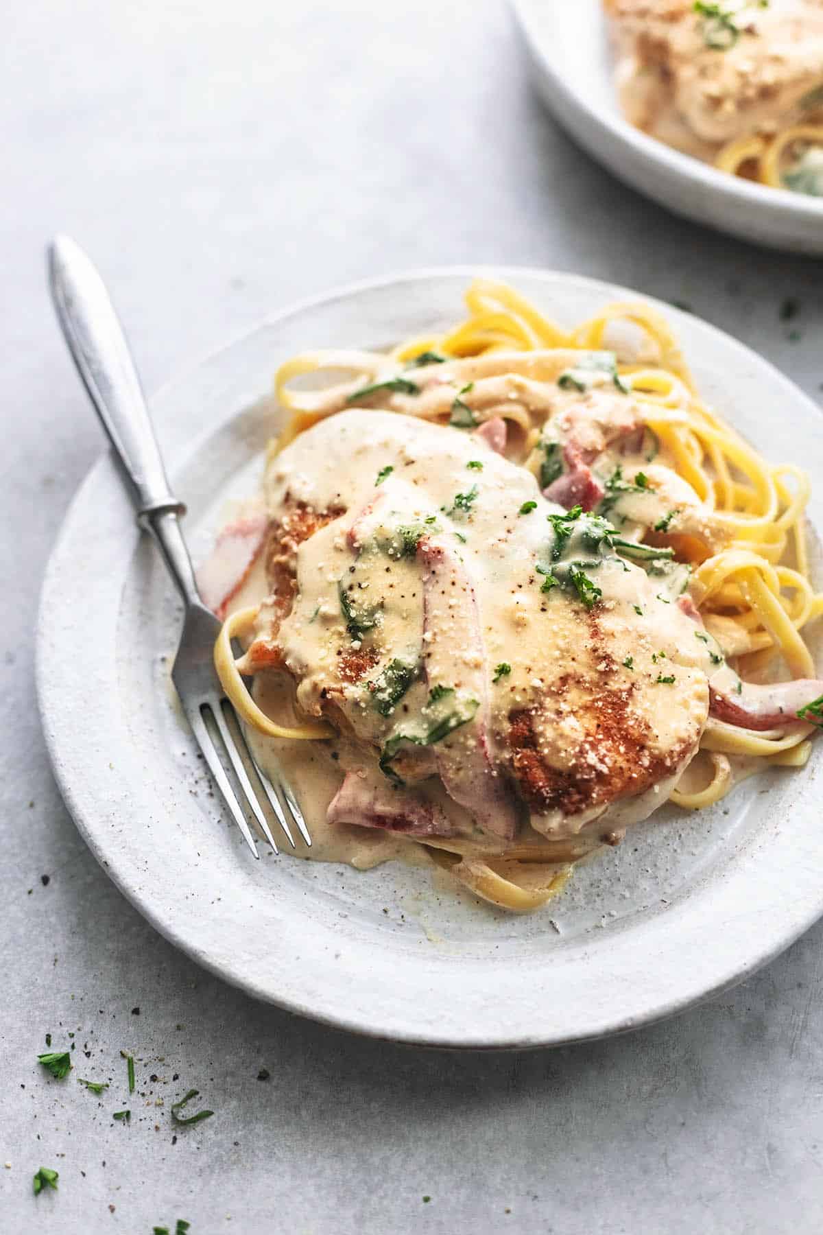 chicken with sauce with spinach over fettuccine noodles