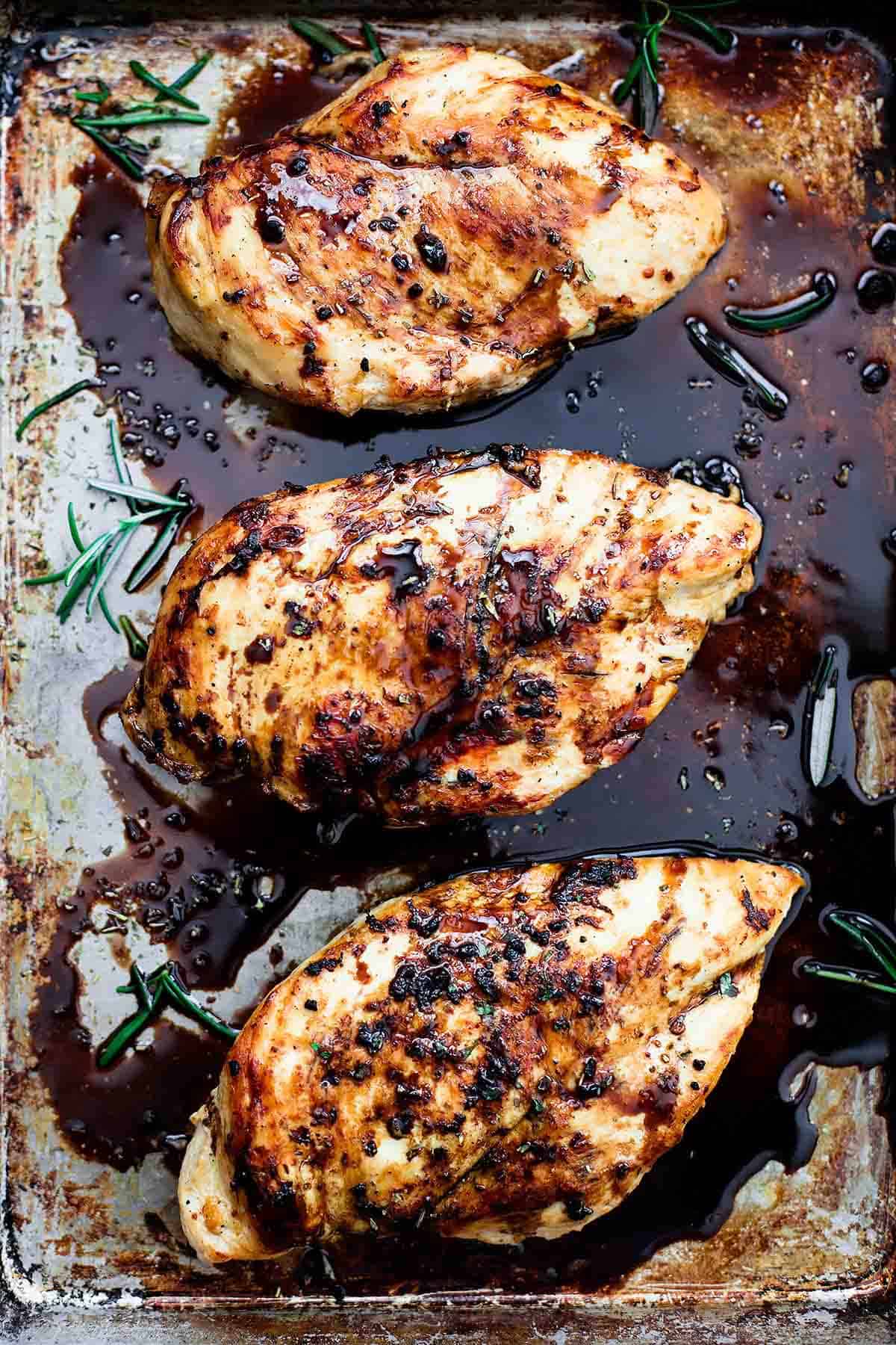 close up of baked balsamic chicken on a baking sheet.