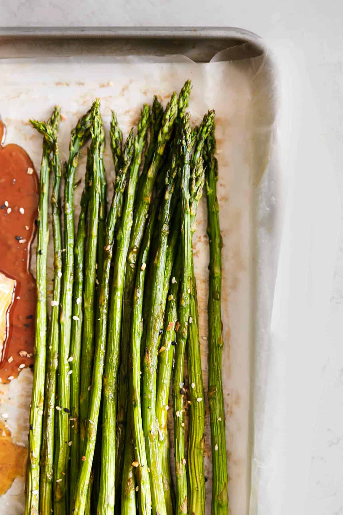 close up top view of asparagus on a baking sheet.