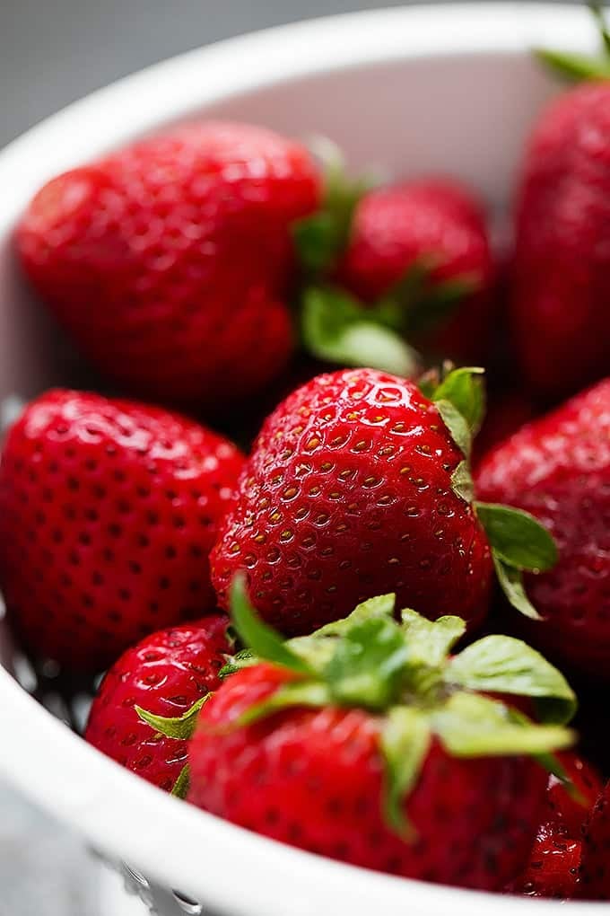 close up of strawberries in a bowl.