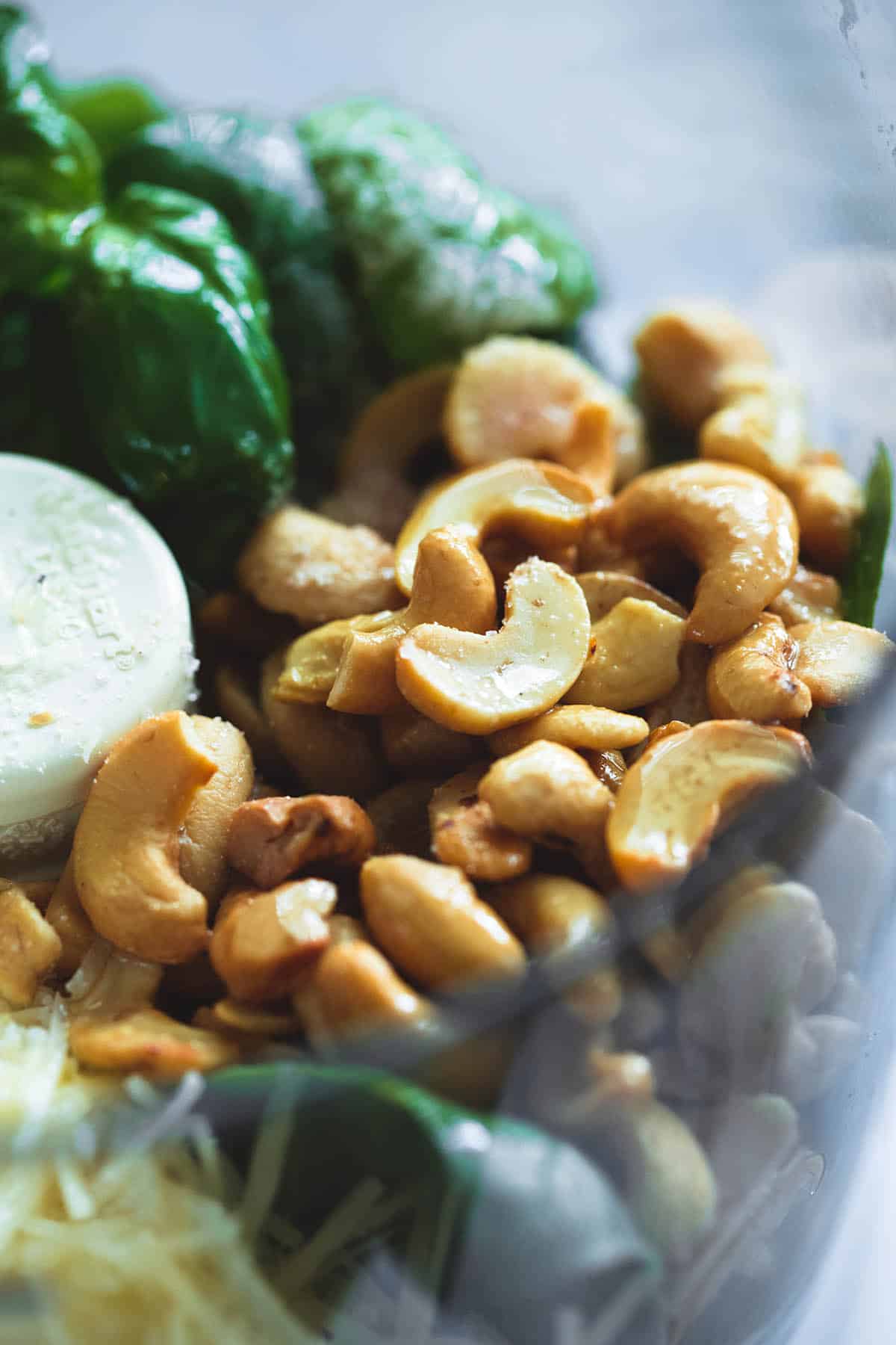 close up of cashew pesto ingredients unblended in a blender.