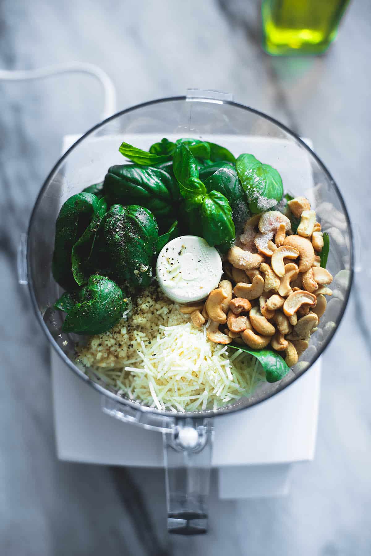 top view of cashew pesto ingredients unblended in a blender.