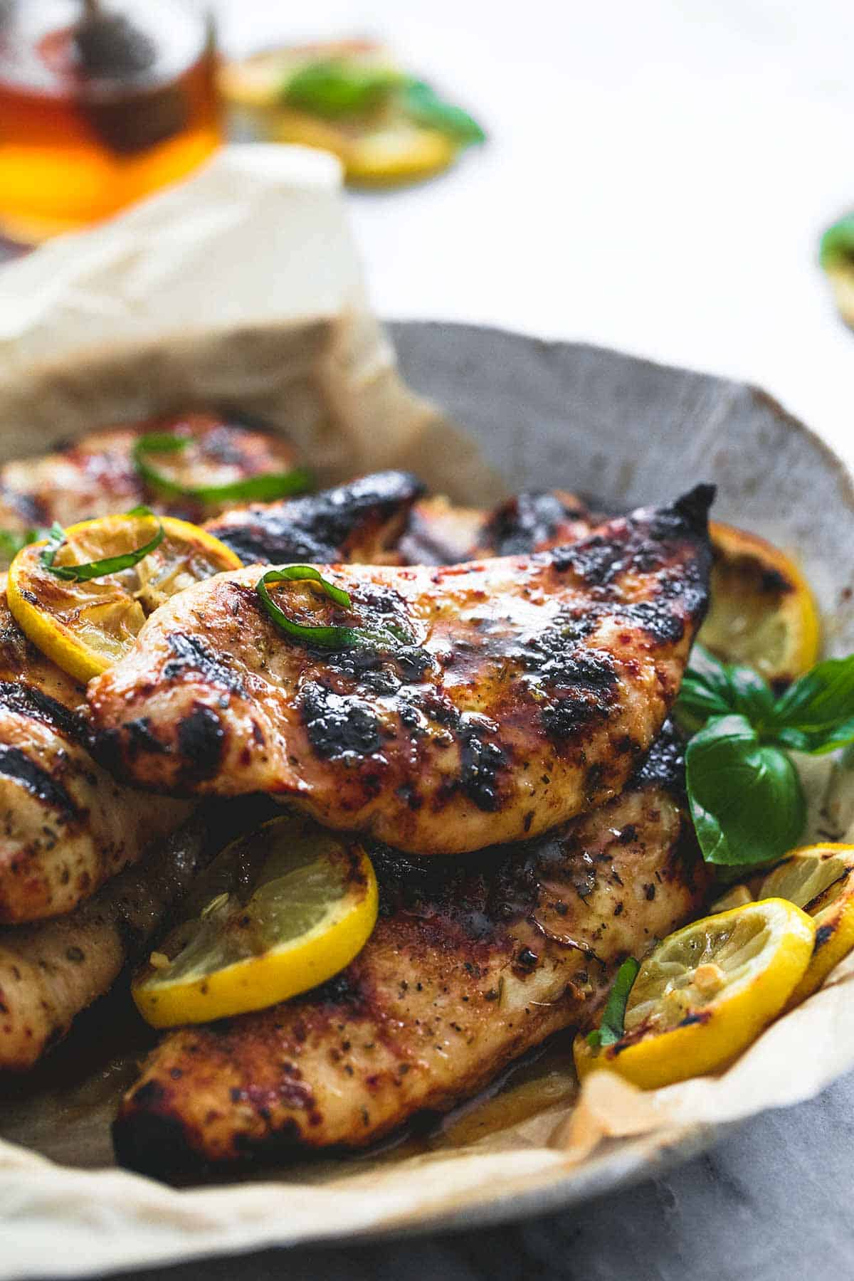 grilled honey lemon chicken with lemon wheels on a plate.