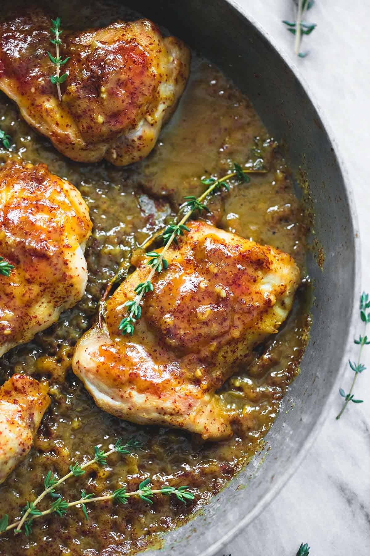 close up of maple mustard glazed chicken in a skillet.