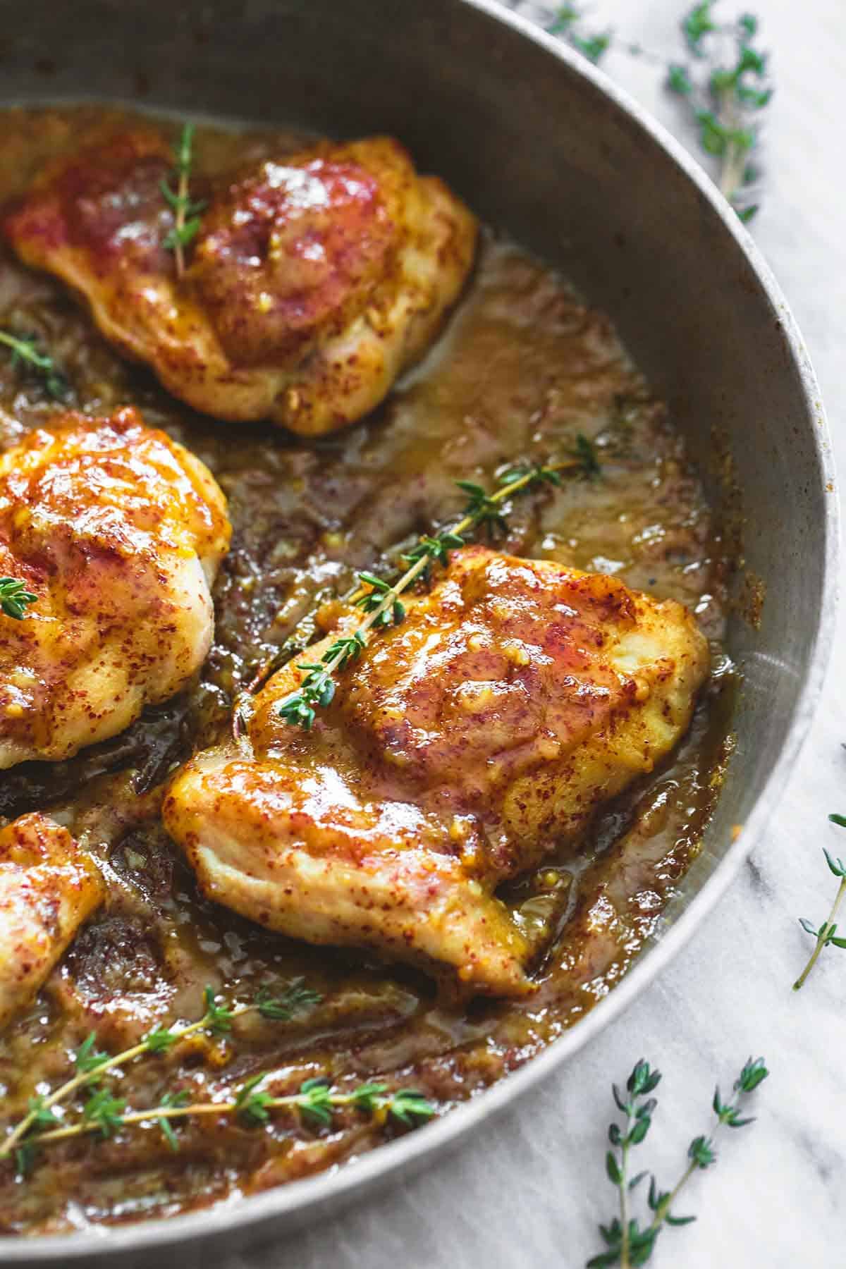 close up of maple mustard glazed chicken in a skillet.